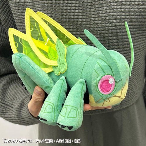 A plushie version of the Chemy Hopper1, the body a soft shade of green, the wings a light shade of green, the 'mouth' and underbelly a yellow shade of green, and the eyes a bright shade of purple. It is held by a person wearing gray so as not to distract from the appearance of the plushie.